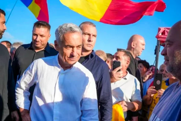 Bărbat în cămașă albă la miting cu steag românesc