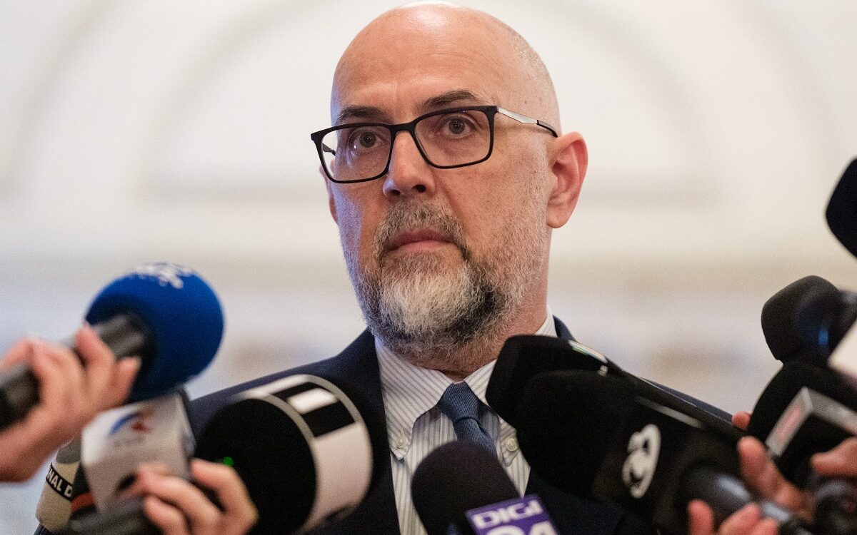 Bărbat chel cu ochelari la conferință de presă