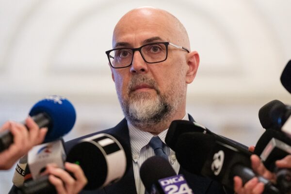 Bărbat chel cu ochelari la conferință de presă