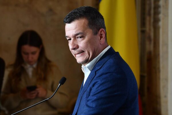 Bărbat în costum vorbind la pupitru oficial