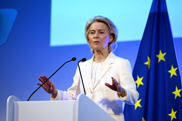 Femeie vorbind la pupitru, steagul Uniunii Europene