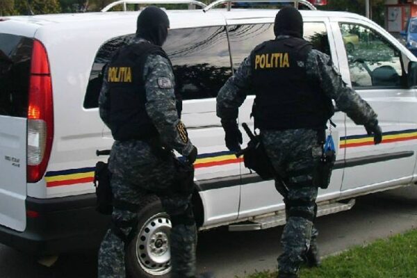 Polițiști mascați lângă dubă inscripționată Poliția